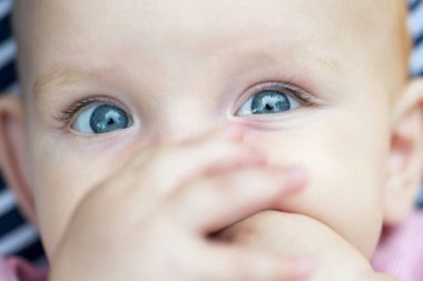 Bebek portresi. Parlak mavi gözlü, yakın bir yüz. Sevimli bebek