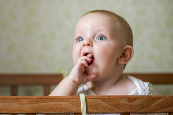 Lindo bebé parado en una cama. Un niño sonriente jugando en la cama. Retrato de niño en la guardería. Concepto de infancia feliz — Foto de Stock