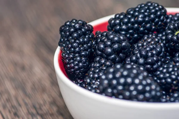Plate with blackberries. Blackberries on wooden background. Sweet, ripe blackberries in bowl — Stock Photo, Image