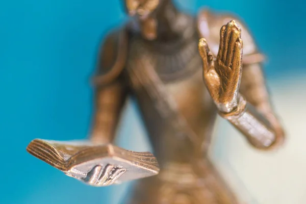 Primer plano de la mano de una estatua de bronce sosteniendo un libro abierto y otra mano arriba. Escultura de cerca. Pequeña profundidad de campo — Foto de Stock