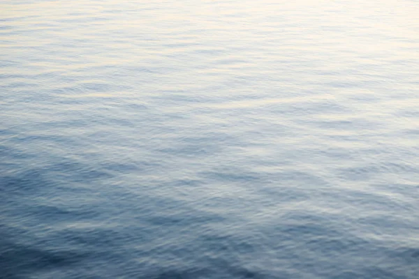Kék tengervíz háttér. Nyugodt vízfelszín kis hullámai — Stock Fotó
