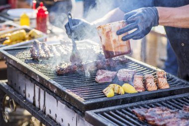 Barbeküde pişmiş et. Metal şişte pişen ızgara kebap. Barbekü taze et dilimleri. Mangal kömürü ve alevler, sokak yemekleri.