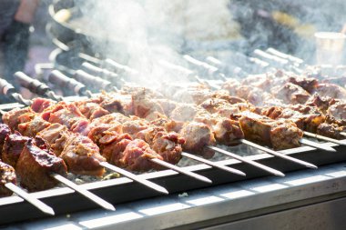 Karışık et tabağı. Türlü lezzetli ızgara et. Şiş üzerindeki et ateşte kızarıyor. Kömürün üstünde mangal ızgarasında dumanlı et.