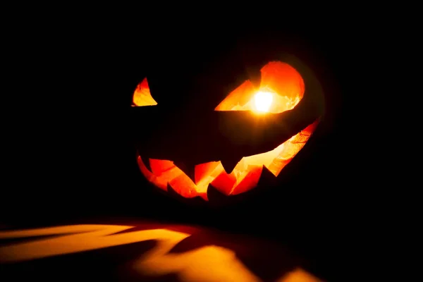 Halloween pumpa leende och skrämmande ögon för fest kväll. Närbild av skrämmande Halloween pumpa med ögon glöder inuti på svart bakgrund. Selektiv inriktning — Stockfoto