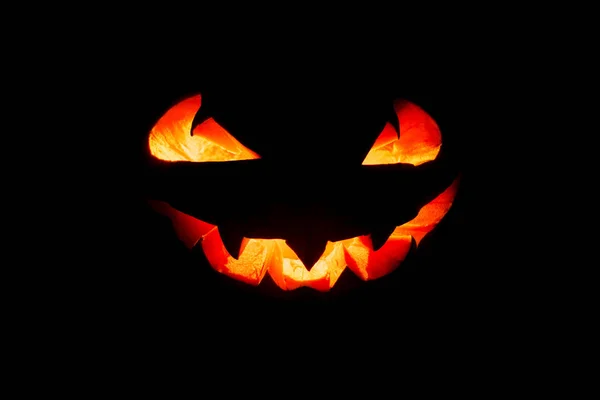 Halloween dyniowy uśmiech i przerażające oczy na noc party. Zamknij widok przerażający Halloween dyni z oczami świecącymi wewnątrz na czarnym tle. Skupienie selektywne — Zdjęcie stockowe