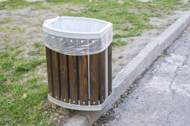 Parkta umumi çöp tenekesi. Kamu alanındaki ahşap çöp kutusu..