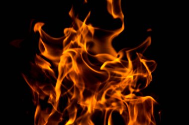 Yangın alevleri siyah arka planda soyuttur. Koyu arkaplanda ateş ve yanan alev.