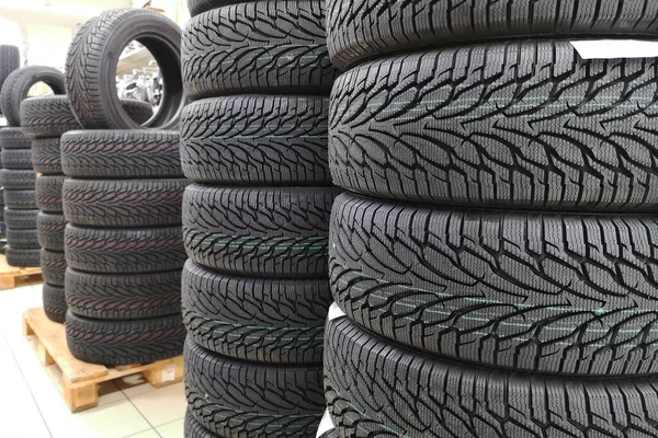 Car tires in auto store. Tires for sale in a tire store - stacks of new tires.