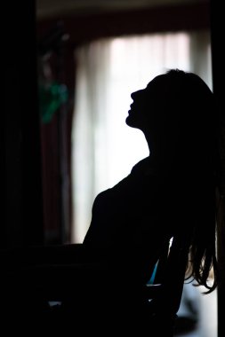 Evin penceresinin yanında seksi bir kadının silüeti..