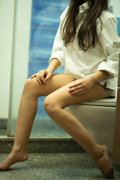 Sabahları tuvalette oturan, seçici odaklı bir kadın..