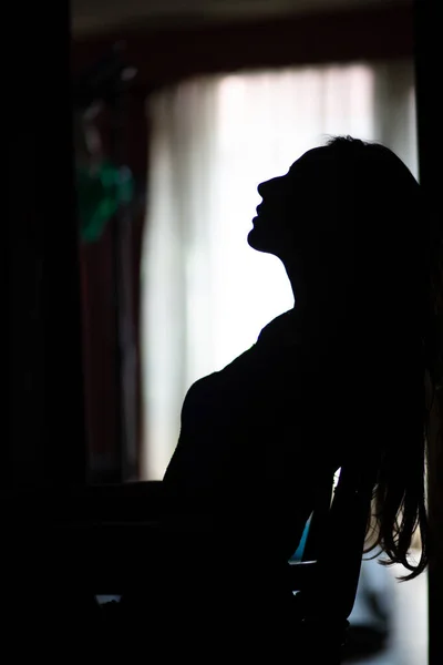 Evin penceresinin yanında seksi bir kadının silüeti..