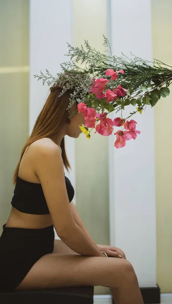 Kırmızı Sarı Çiçekler İçinde Bir Kadın Oturuyor.