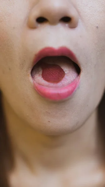 Ağzında gül yaprağı olan bir kadın.