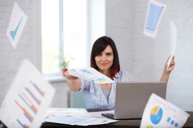 Mutlu ve gülümseyen kadın işçi düşen kağıtları ile Office belgeleri atar. Zamanlı iş bitirme. Zaman yönetimi, son tarih kavramı.