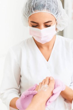 Profesyonel ayak masajı nemlendirici köpük kullanarak. Profesyonel pedikür son aşaması. Cilt yumuşatıcı, sert cilt yumuşatma. Hasta ziyaret ayak hastalıkları uzmanı. Ayak tedavi Spa salonda. Podiatry Kliniği.