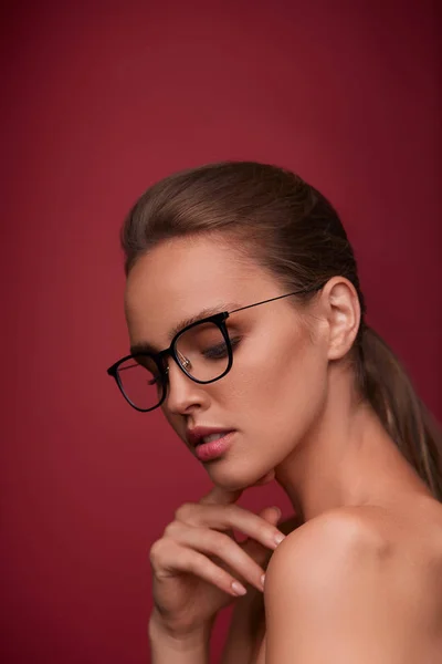 Atrakcyjna Kobieta Kwadratowych Okulary Patrząc Kamery Czerwonym Tle Portret Młoda — Zdjęcie stockowe