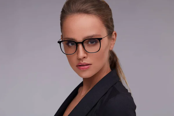 Mulher Séria Elegante Óculos Quadrados Olhando Para Câmera Fundo Cinzento — Fotografia de Stock