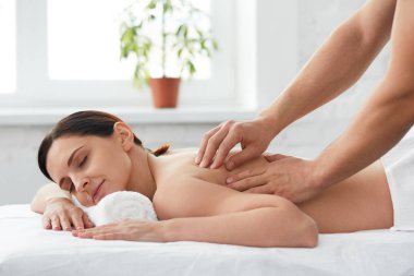 Genç güzel kadın bir sırt masajı zevk. Profesyonel masaj terapisti daire bir kadın hastada tedavi ediyor. Gevşeme, güzellik, vücut ve yüz tedavi kavramı. Evde Masaj.