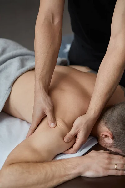 Ung Vacker Man Njuter Ryggmassage Professionell Massageterapeut Behandlar Manlig Patient — Stockfoto