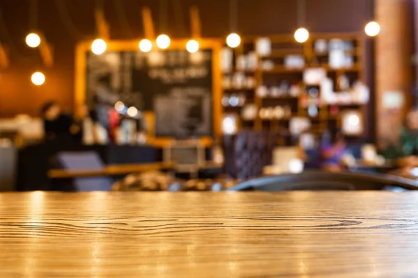 Kahve dükkanı arka plan bulanık ahşap üst masa. Ürünlerinizi sergilemek veya montajiçin ahşap masayı türün. Kafe veya kafede bulanıklık, restoran arka planı.