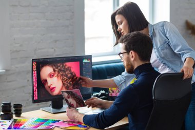 Ofiste dizüstü bilgisayar, monitör, grafik çizim tableti ve renk paleti ile çalışan fotoğrafçı ve grafik tasarımcısı. Reklam ajansında fikirleri tartışan bir ekip yaratmak. Görüntüler alınıyor. Takım çalışması.