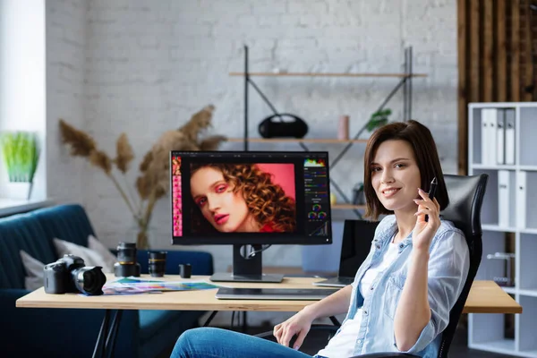 Portret van grafisch ontwerper die werkt in het kantoor met laptop, monitor, grafische tablet en kleurpalet.Retoucheren van beelden in speciaal programma.Retoucher werkplek in fotostudio.Creative agency — Stockfoto