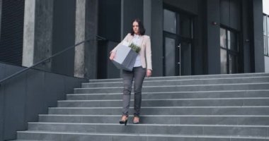 Müdürün görevden alınması. İşten atıldığı için stres altında olan bir kadın. Görevden alınan personel, elinde bir eşyayla ofisten çıkıyor.