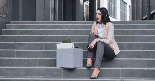 Avskedande av chefen. Kvinna i stress på grund av uppsägning från arbetet. Uppsagd anställd lämnar kontoret med en tillhörigheter i rutan — Stockvideo