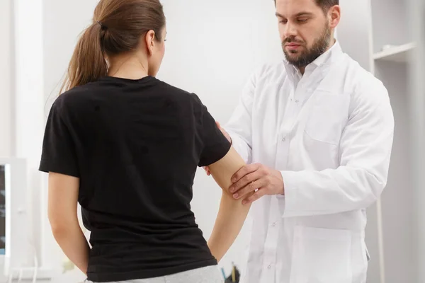 Médico examinando paciente do sexo feminino que sofre de dor no cotovelo. Exame médico. Quiropraxia, osteopatia, reabilitação pós-traumática, fisioterapia desportiva. Medicina alternativa, conceito de alívio da dor — Fotografia de Stock