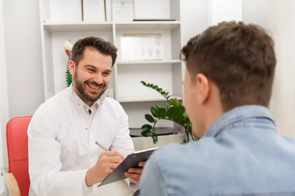 Médecin et patient au cabinet médical. Thérapeute parler à un patient au bureau, prendre des notes, rédiger une ordonnance. Consultation à la clinique. Concept de santé et de médecine — Photo