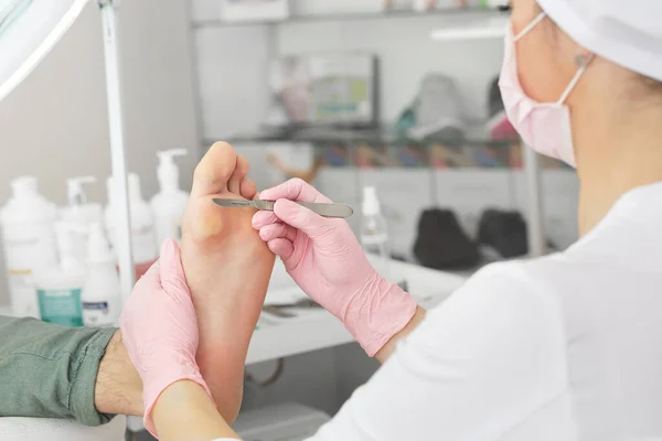 전문적 인 페디큐어 사용 dieffenbach calpel.Patient visiting podiatrist.Medical pedicure procedure using special instrument with knife holder.foot treatment in SPA salon.Podiatry Clinic — 스톡 사진