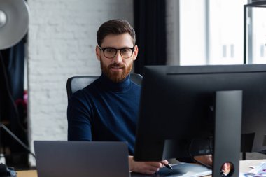 Özel programdaki resimler alınıyor. Dizüstü bilgisayar, monitör, grafik çizim tableti ve renk paleti ile çalışan grafik tasarımcısının portresi. Fotoğraf stüdyosundaki çalışma yeri. Yaratıcı ajans