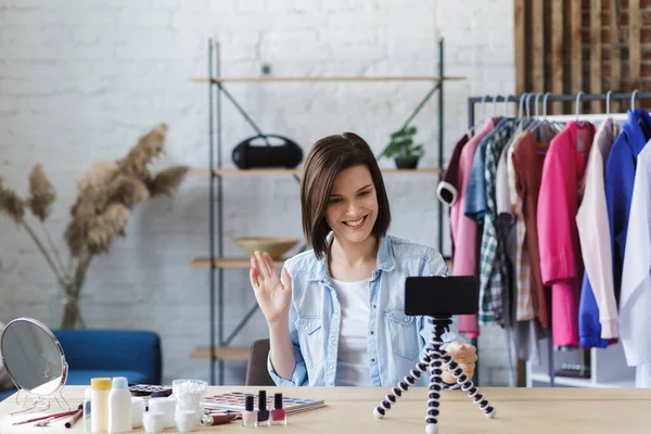 Vlogger enciende la cámara en el teléfono móvil y transmite video en vivo a la red social en casa.Una joven blogger grabando un video tutorial para su blog de belleza sobre cosméticos. Blogging, concepto de maquillaje — Foto de Stock