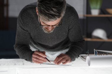 Mimar ofiste planlar çiziyor. Mühendis bir inşaat projesi çiziyor. Mimari plan. Yakışıklı sakallı adamın işine odaklanmış yakın plan portresi. İş inşa kavramı