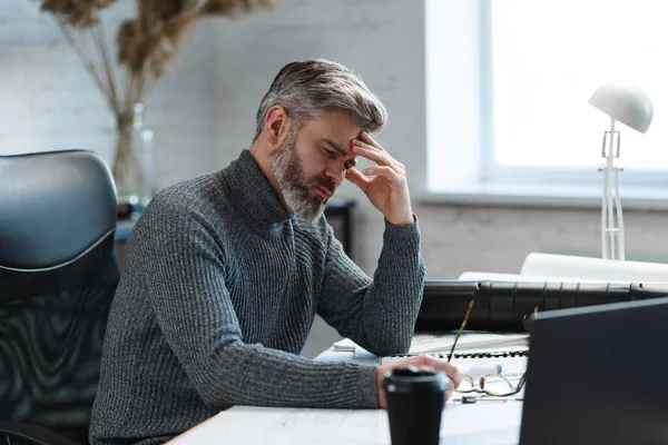 Arquiteto cansado trabalhando horas extras no escritório. Empresário estressado tem problemas financeiros e busca de ideias para superar a crise financeira. Empreendedor em falência. Conceito de esgotamento e excesso de trabalho — Fotografia de Stock