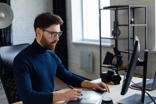 Retoucheren van beelden in speciaal programma.Portret van grafisch ontwerper die werkt in het kantoor met laptop, monitor, grafische tablet en kleurpalet.Retoucher werkplek in fotostudio.Creative agency — Stockfoto