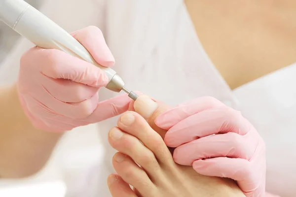 Patient på medicinsk pedikyr förfarande, besök fotvårdsspecialist.Professionell hårdvara pedikyr med hjälp av elektrisk maskin.Peeling fötter med speciell elektrisk enhet.Fotbehandling i SPA salong .Podiatri klinik — Stockfoto