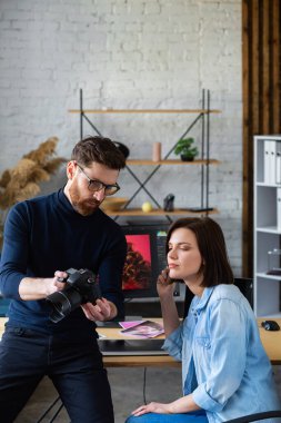 Ofiste dizüstü bilgisayar, monitör, grafik çizim tableti ve renk paleti ile çalışan fotoğrafçı ve grafik tasarımcısı. Reklam ajansında fikirleri tartışan bir ekip yaratmak. Görüntüler alınıyor. Takım çalışması.