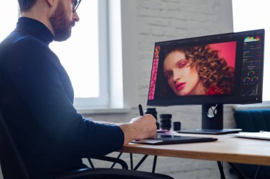 Özel programdaki resimler alınıyor. Dizüstü bilgisayar, monitör, grafik çizim tableti ve renk paleti ile çalışan grafik tasarımcısının portresi. Fotoğraf stüdyosundaki çalışma yeri. Yaratıcı ajans