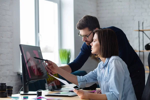 Fotograf och grafisk formgivare arbetar på kontoret med laptop, monitor, grafisk ritplatta och färgpalett. Skapa team diskuterar idéer i reklambyrå. Retuscherar bilder. Lagarbete — Stockfoto