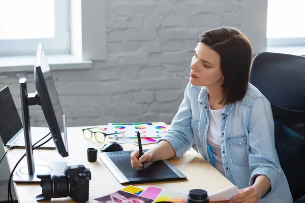 Portret grafika pracującego w biurze z laptopem, monitorem, tabletem graficznym i paletą kolorów.Retuszowanie obrazów w specjalnym programie.Miejsce pracy Retoucher w studiu fotograficznym.Agencja kreatywna — Zdjęcie stockowe