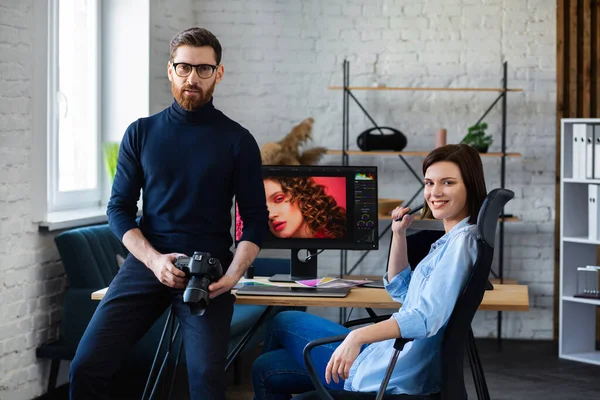 Photographer and graphic designer working in office with laptop, monitor, graphic drawing tablet and color palette. Creating team discussing ideas in advertising agency. Retouching images. Teamwork