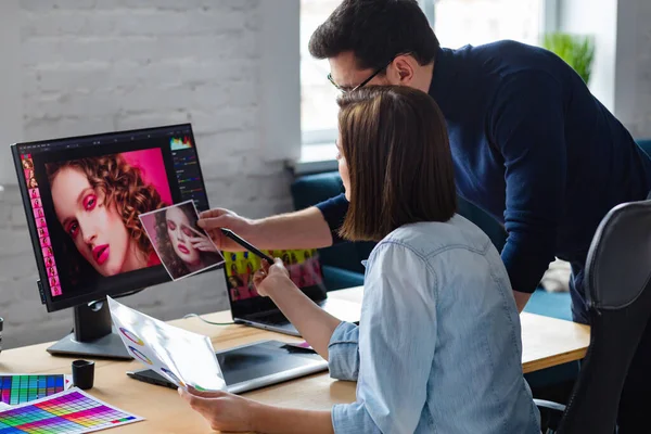 Ofiste dizüstü bilgisayar, monitör, grafik çizim tableti ve renk paleti ile çalışan fotoğrafçı ve grafik tasarımcısı. Reklam ajansında fikirleri tartışan bir ekip yaratmak. Görüntüler alınıyor. Takım çalışması.