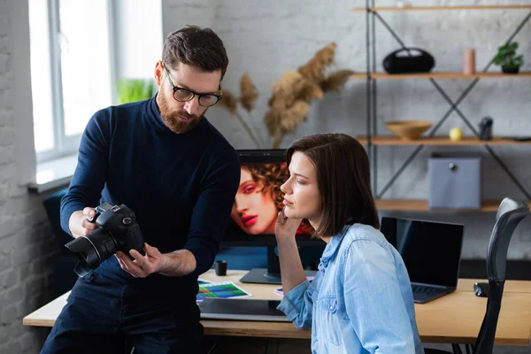 Fotograf i grafik pracujący w biurze z laptopem, monitorem, tabletem graficznym i paletą kolorów. Tworzenie zespołu omawiającego pomysły w agencji reklamowej. Retuszowanie obrazów. Praca zespołowa — Zdjęcie stockowe