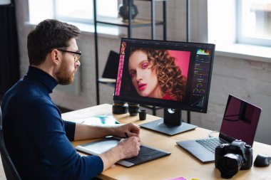 Özel programdaki resimler alınıyor. Dizüstü bilgisayar, monitör, grafik çizim tableti ve renk paleti ile çalışan grafik tasarımcısının portresi. Fotoğraf stüdyosundaki çalışma yeri. Yaratıcı ajans