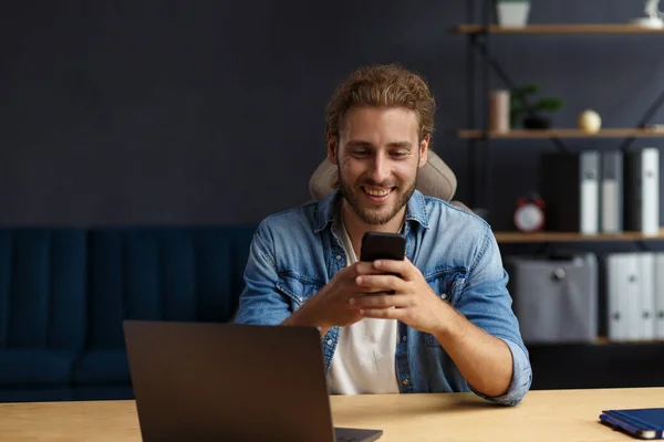 Young man using smartphone and smiling. Happy businessman using mobile phone apps, texting message, browsing internet, looking at smartphone. Concept of young people working with mobile devices — Stock Photo, Image