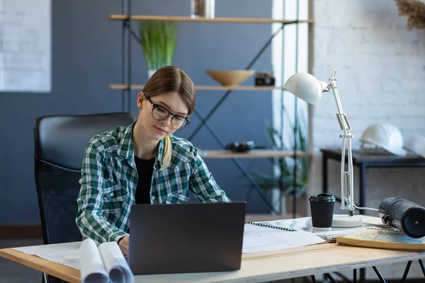 Vrouwelijke interieurontwerper aan het werk met laptop. Architect denkt na over architectuurplan, op zoek naar nieuwe ideeën voor bouwproject. Vrouw op het werk. Bedrijfsportretconcept — Stockfoto