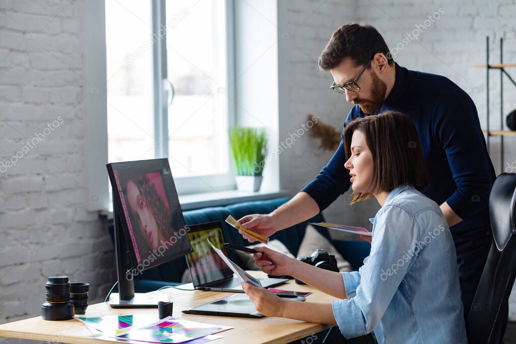 Photographer and graphic designer working in office with laptop, monitor, graphic drawing tablet and color palette. Creating team discussing ideas in advertising agency. Retouching images. Teamwork