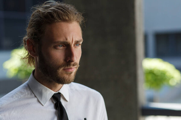 Portrait of a handsome curly-haired man, in a business style. The astute look of an attractive businessman