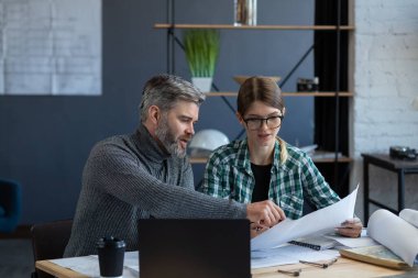 İç mimar ekibi planlar, mimarlık ekipmanları, çizimler, pazarlıklar ve inşaat projeleri ile birlikte çalışıyor. Ortaklar iş yerinde tartışıyor. İş inşa kavramı